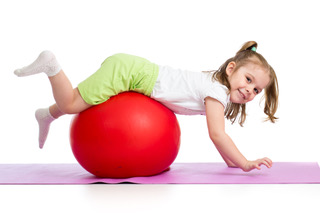 Young girl balancing on a therapy ball