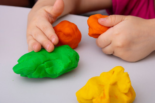 Child's hands shaping colorful play dough